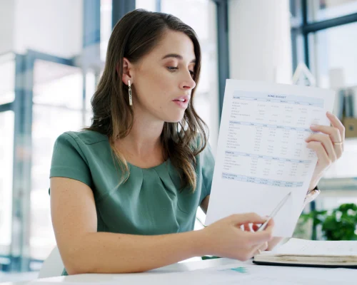 Assistante maternelle vérifiant son bulletin de salaire Pajemploi ligne par ligne